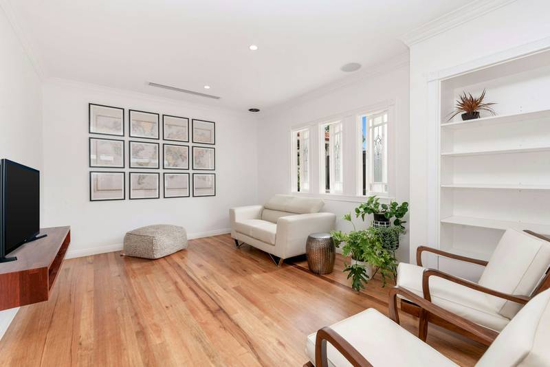 A living room with a bare wood floor and pale walls. Reference photograph.