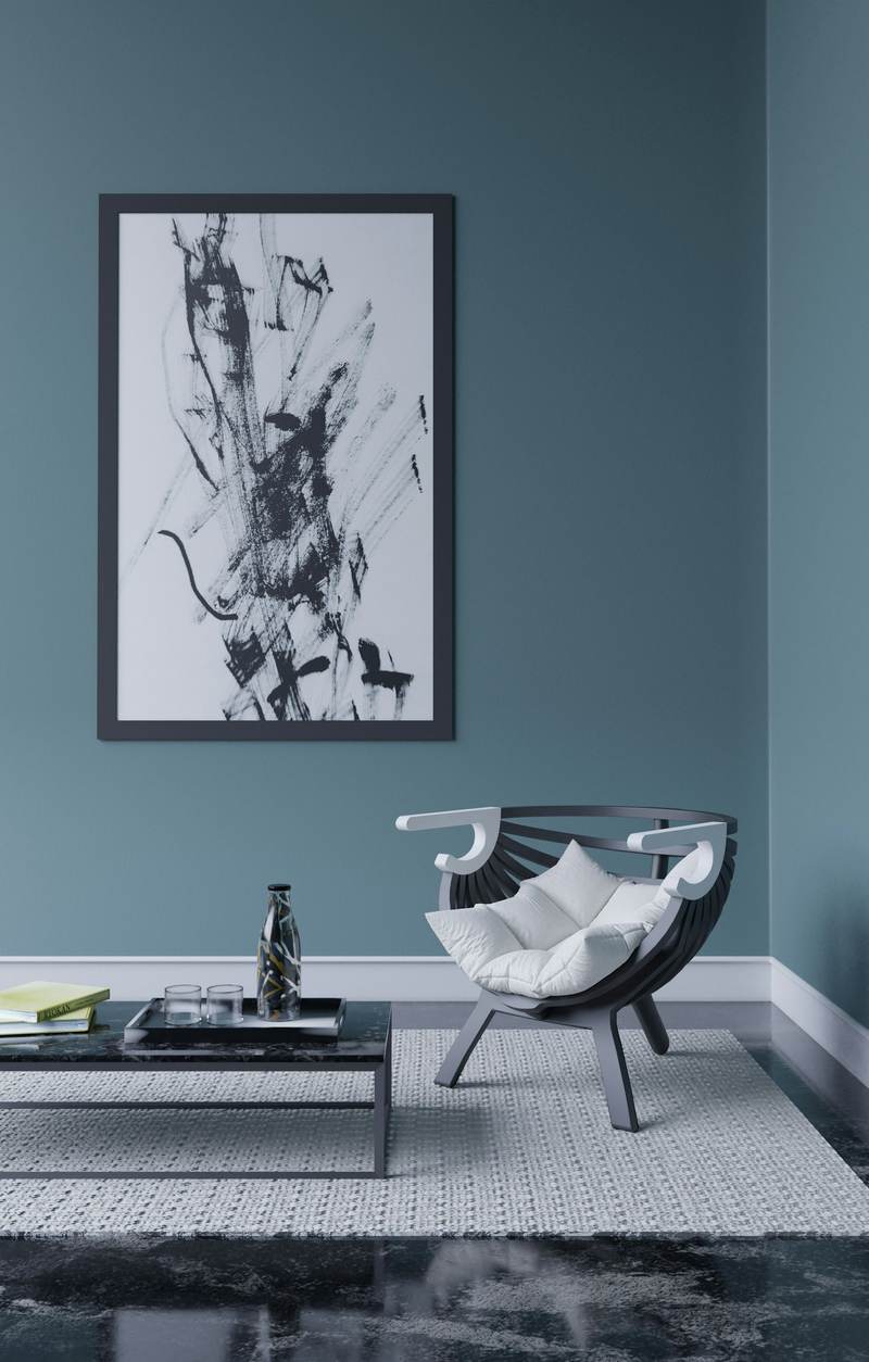A room with a deep teal wall and a single chair. Reference photograph.
